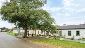 Zona residencial con un árbol grande, casas y una calle pavimentada.