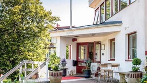 A building with a reception area, a staircase, and outdoor seating. - 2 Person Holiday Park Home in Bastad (Bastad)
