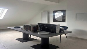 A modern room with a large table displaying electronic devices and their boxes. - Elegant Appt - 3BDR/8P - Near Paris & La Défense (Suresnes)