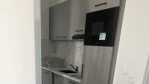 A kitchen with a microwave, a sink, and cabinets.