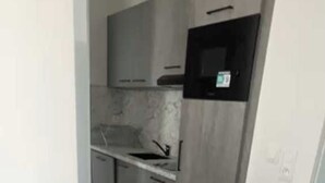 Una cocina con microondas, un fregadero y armarios.