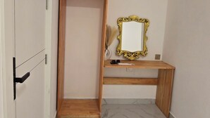 A room with a marble floor, a wooden door, a desk with a mirror, and an air conditioning unit on the wall. - Charming 2-bedroom bed & breakfast in lovely Felidhoo with AC (Felidhoo)