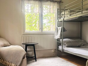 A bunk bed room with a window, a small table, and a bed with a patterned blanket. - 4 Person Holiday Park Home in Vaxholm (Vaxholm)