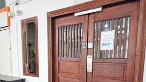 A wooden double door with a push sign, a welcome mat, and a small window with a view of the outside. - Heliconia by Treebridge (George Town)