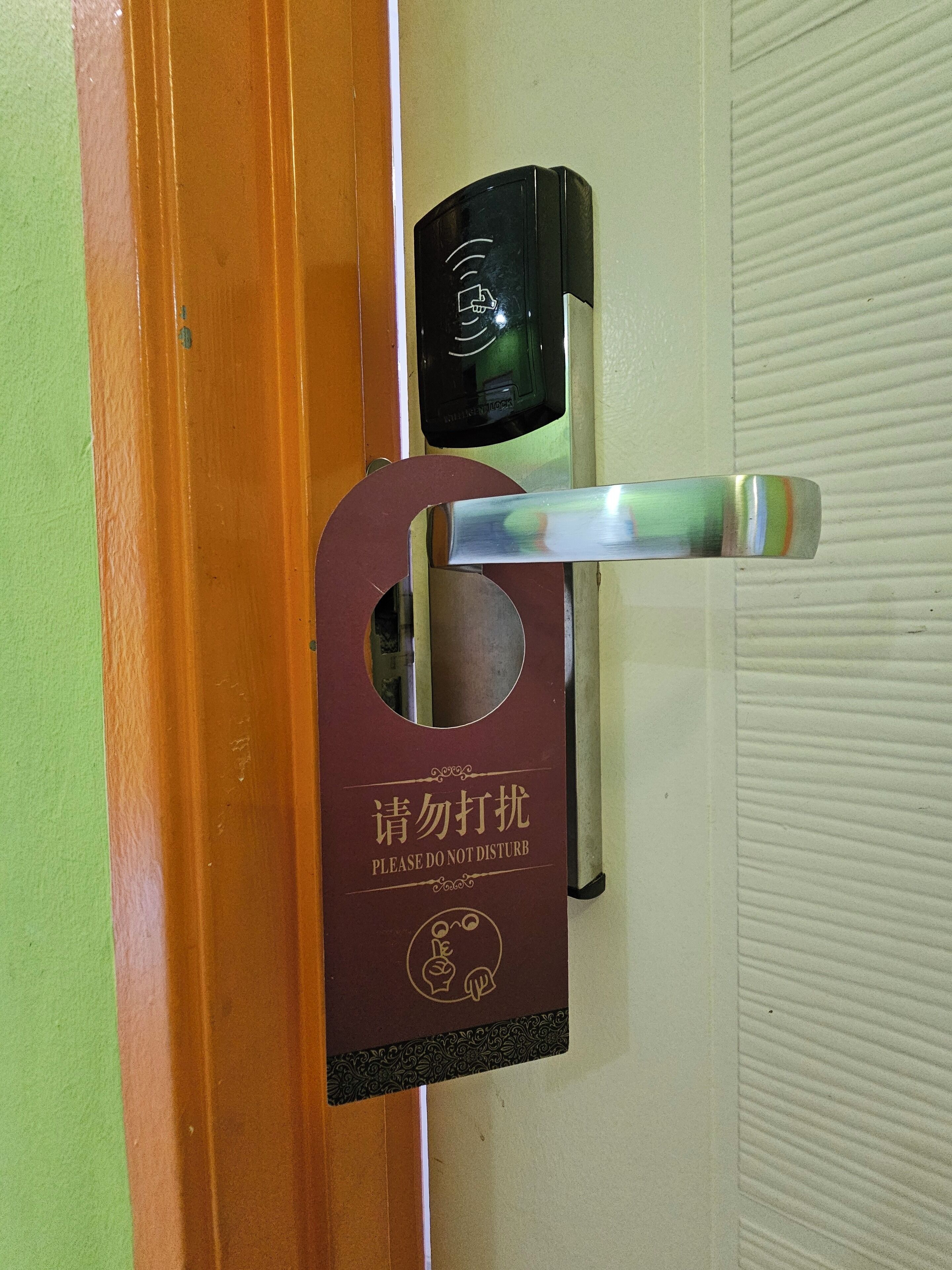 Uma porta com um aviso de 'Não Perturbe' e leitor de cartão-chave.