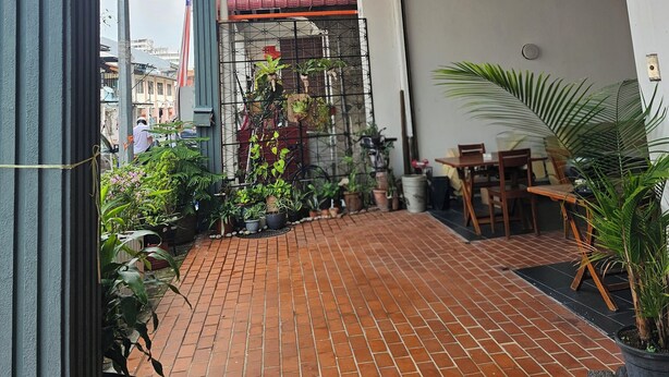 A covered patio area with a brick floor, potted plants, and a ceiling fan. - Heliconia by Treebridge (George Town)
