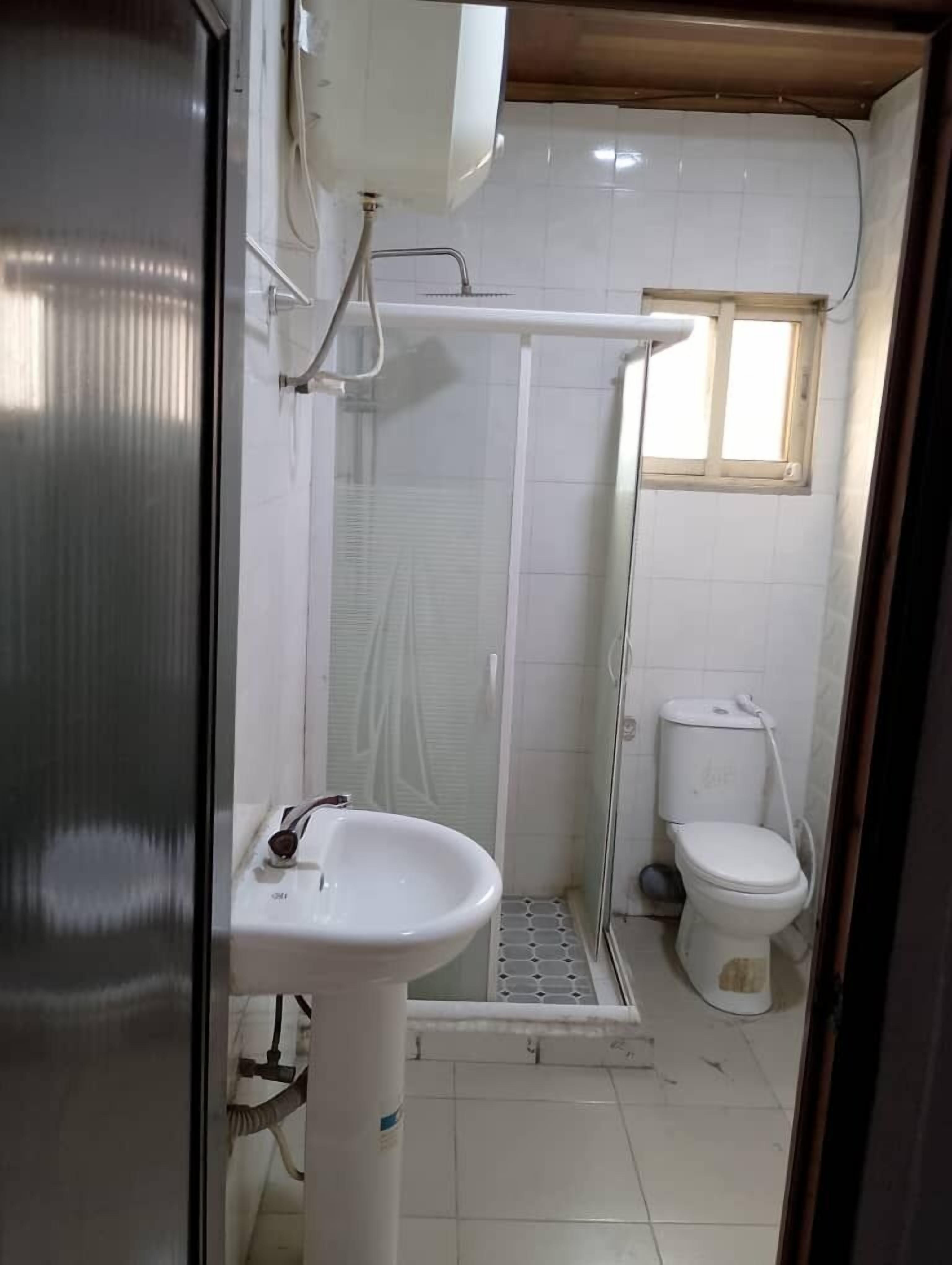 A bathroom with a shower, toilet, and sink.