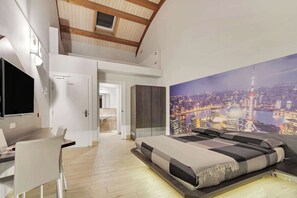 Une chambre moderne avec un grand lit, un bureau et une télévision.