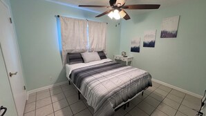 A bedroom with a bed, a ceiling fan, a nightstand, and wall art. - Spacious 3-bedroom house in brilliant Austin  /The Domain & Q2 Stadium/ (Austin)