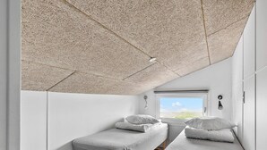 A small, modern room with two single beds, a window with a view, and a ceiling with a unique texture. - 6 Person Holiday Park Home in Faaborg (Faaborg)