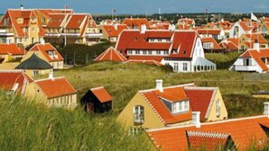 A coastal village with red-roofed houses and a white building with a pointed roof. - 4 Person Holiday Park Home in Skagen (Skagen)