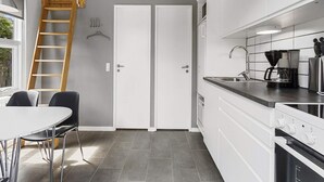A compact kitchen with white cabinets, a built-in oven, and a coffee maker. - 4 Person Holiday Park Home in Skagen (Skagen)