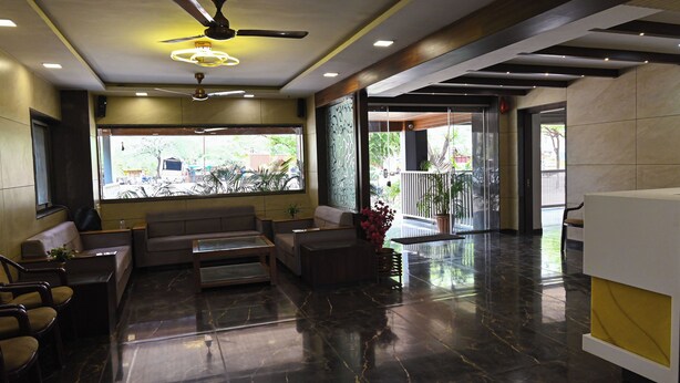 Een moderne lobby met plafondventilator, zithoek en receptiebalie.