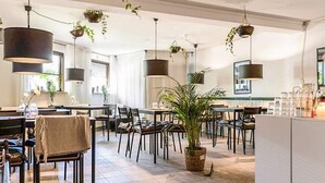 A spacious dining area with multiple tables and chairs, hanging plants, and pendant lighting. - 2 Person Holiday Park Home in Bastad (Bastad)