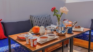 Une table dressée pour le petit-déjeuner, avec des cafetières, des bols et un vase rempli de fleurs.