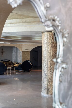 An interior space with a marble column, a sofa, and a patterned rug. - Saint George Palace - All Inclusive (Sveti Vlas)