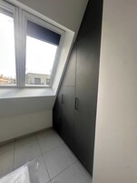 A room with a skylight, dark cabinets, and a tiled floor.
