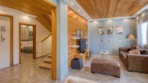 A modern living room with a wooden ceiling, a TV, a sofa, and a coffee table. - Prime Holidays Mountain View Ras ElHekma (El Dabaa)