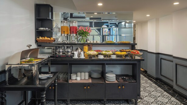 Disposición de bufé con diversos alimentos, electrodomésticos de cocina y utensilios de servicio.
