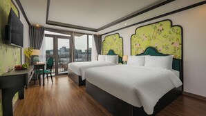 Habitación de hotel con dos camas, televisión, escritorio y una silla.