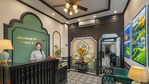 Una zona de recepción con un cartel que dice 'Jasmine Premium Hotel & Travel'.