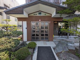 Una entrada de edificio con un camino empedrado que conduce a una puerta de cristal.