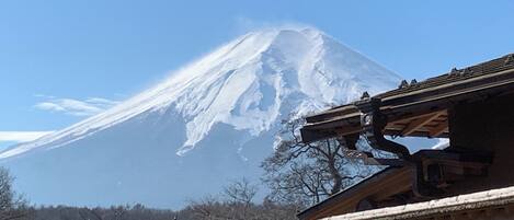 A traditional Japanese building with a snow-capped mountain in the background.