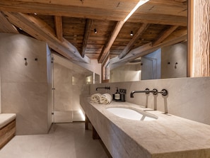 A modern bathroom with a large sink, wooden beams, and a glass shower enclosure. - Luxurious 6-room apartment with hammam, fireplace and parking in Val-d'Isère (Val-d'Isère)
