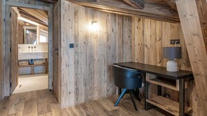 Ein Holzinnenraum mit Schreibtisch, Lampe und Regalen.