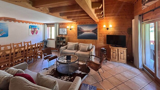 A cozy wooden cabin interior with a sofa, chairs, a TV, and a fireplace. - 9-person apartment with parking in Tignes Val Claret (Tignes)
