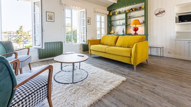 A bright living room with a yellow sofa, a round coffee table, and a green bookshelf. - Modern apartment with large terrace in Ars-en-Ré (Ars-en-Ré)