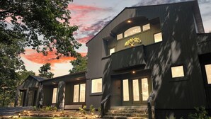A modern two-story house with a large front porch, multiple windows, and a well-maintained garden. - Black Bear Ridge | Games, Hot Tub, Deck w/ Views (Mentone)