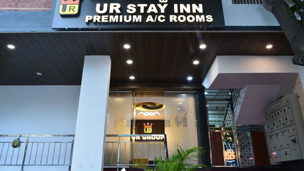 La façade de l’hôtel UR Stay Inn, avec une enseigne indiquant la présence de chambres climatisées de qualité supérieure.