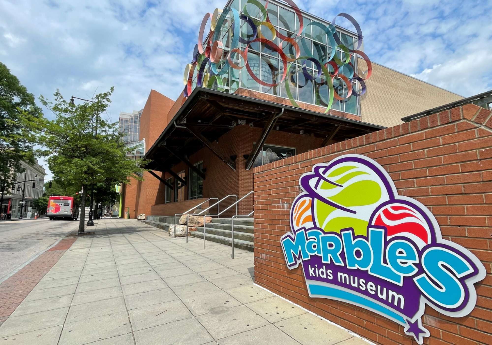 A brick building with a glass facade and a colorful sign for the Marble Kids Museum.