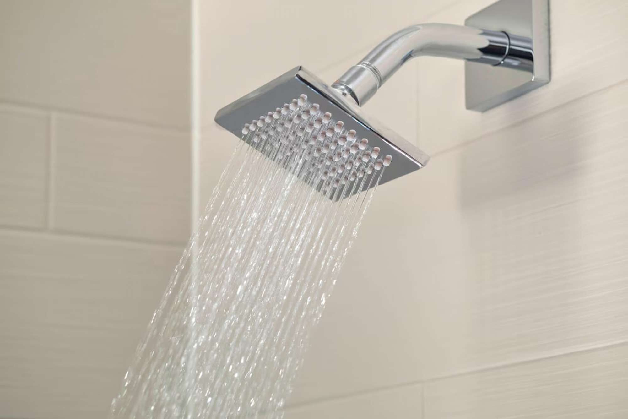 A showerhead with water flowing from it.