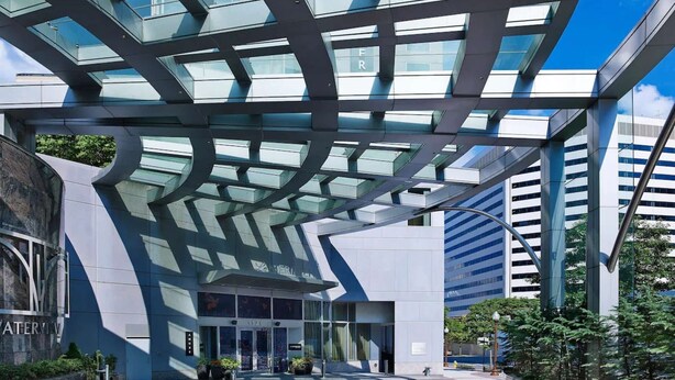 Un edificio moderno con fachada de vidrio y una estructura de techo geométrica única.