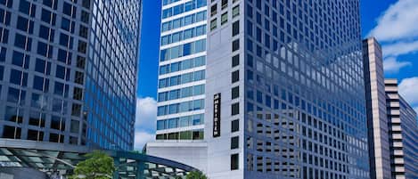 A modern high-rise building with a glass facade and a sign reading "MERIDIAN".