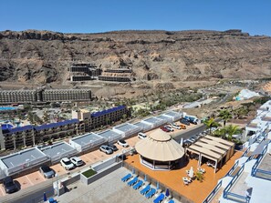 A hotel with multiple buildings, a parking area, and a pool. - Tranquility and view in Taurito Luxholidays (Taurito)