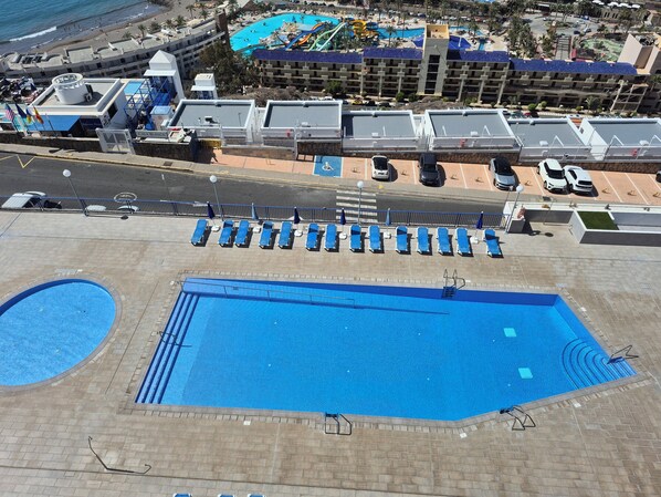 A rooftop pool area with multiple sun loungers and a large central pool. - Tranquility and view in Taurito Luxholidays (Taurito)