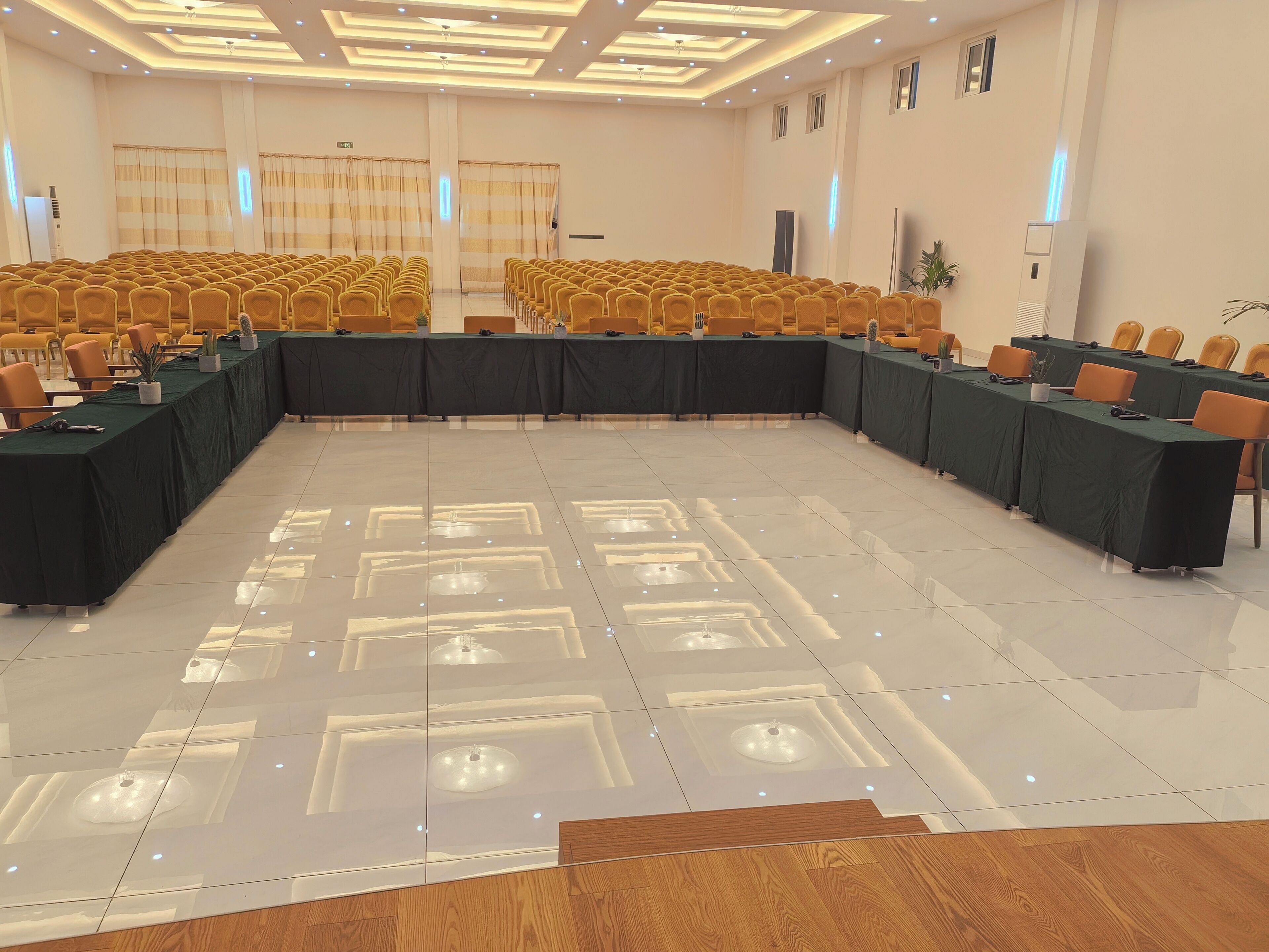A conference room with a long table, chairs, and a polished floor.