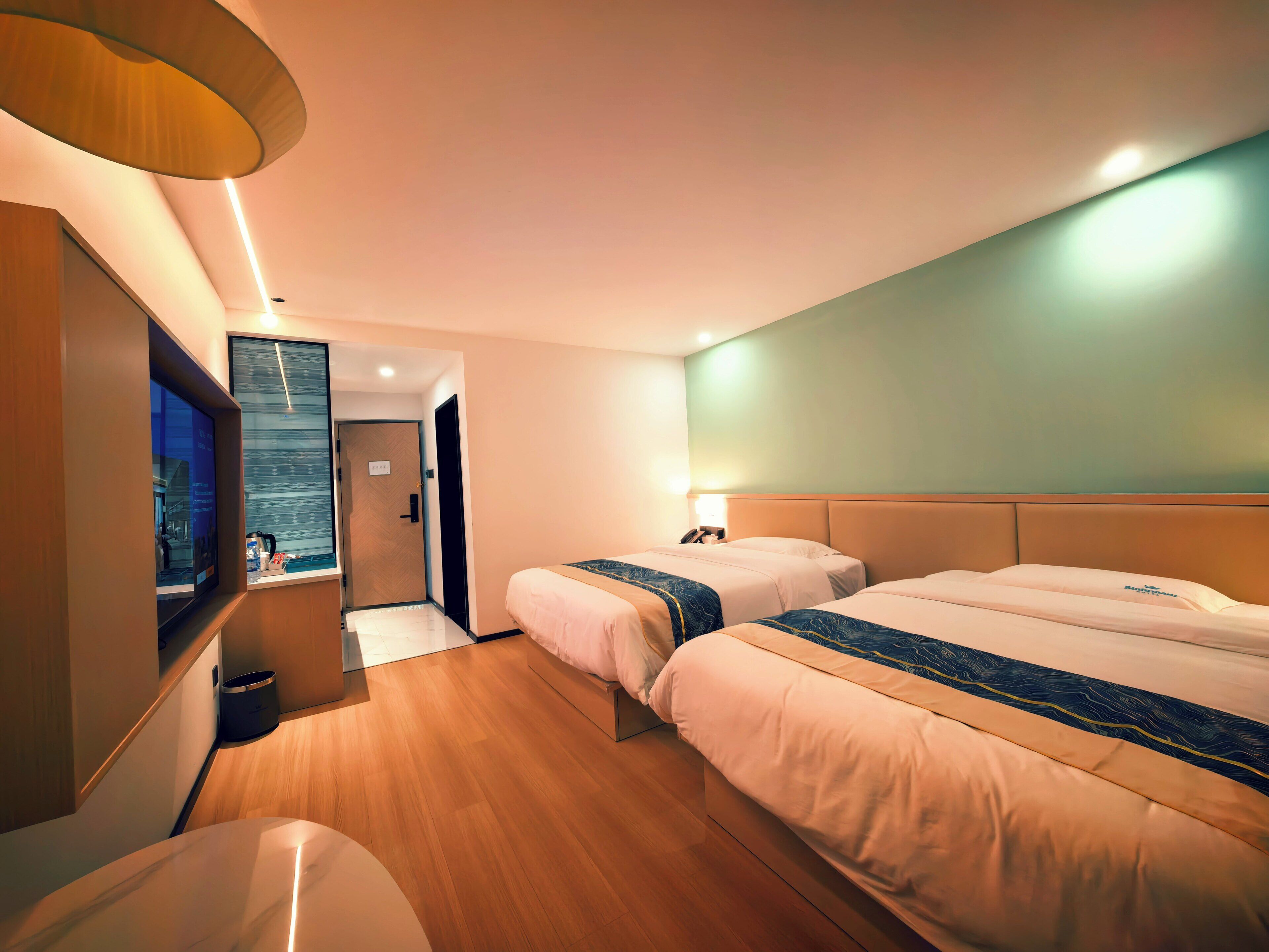 Una habitación de hotel con dos camas, televisión y vista a la ciudad.