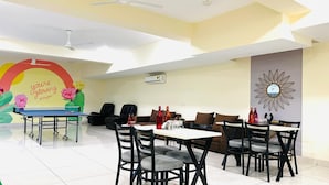 A dining area with a table and chairs, a ceiling fan, and a wall with a decorative mural.