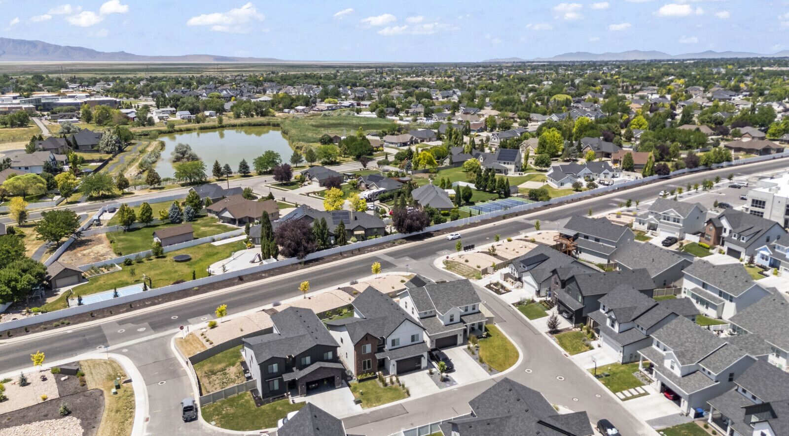 A suburban neighborhood with houses, roads, and a body of water.