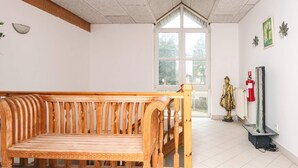 A wooden bench in a room with a large window, a statue, and a fire extinguisher. - 4 Person Holiday Park Home in Romo (Rømø)