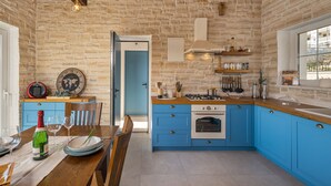 A kitchen with blue cabinets, a stove, and a window. - Villa Katarina with pool (Zadar)