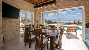 A dining area with a view of a pool and mountains. - Villa Katarina with pool (Zadar)