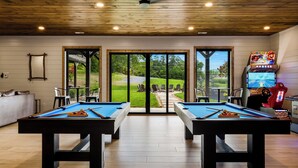 A pool table room with two tables, a sofa, and a Mario Kart gaming station. - Grand Forge Lodge - 16 Bedrooms in the MIDDLE of Pigeon Forge! Loaded! (Pigeon Forge)