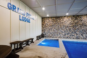 Un espace piscine agrémenté d’un mur en pierre et de bancs.