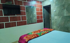 A room with a bed, a mirror, a TV, and a door. - Hotel Kolkar (Panvel)