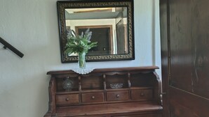 A wooden cabinet with multiple drawers and a mirror above it. - The Bishop's House (Licciana Nardi)